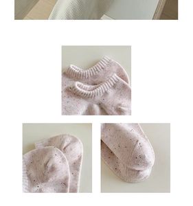 Detailed close-up of pink knit socks showing ribbed cuff and colorful speckled yarn texture