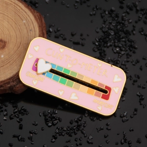 Macro shot of the sliding heart indicator on pink enamel mood meter brooch pins