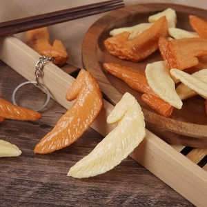 Realistic mini chicken wing food model keychains on a rustic wooden tray decoration