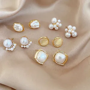 Detailed close-up of 5 pairs of vintage gold-plated pearl and rhinestone stud earrings