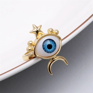 Detail of golden Evil Eye ring with blue pupil, crescent moon and star celestial motifs