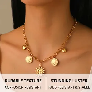 Détail d'un collier chaîne dorée avec pendentifs soleil, pièce et cœur sur mannequin