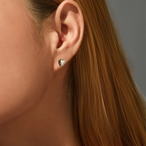 Elegant S925 sterling silver heart stud earrings with shiny crystals worn on model ear