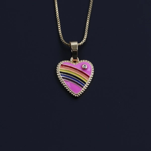 Detail of a golden heart necklace with rainbow enamel stripes and a small sparkling crystal