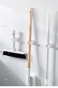 Detail of white wall-mounted mop holder showing non-slip silicone grip and stable hook