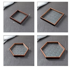 Detailed view of four vintage walnut wood trays with embossed begonia flower glass