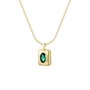 Macro shot of gold ball chain necklace with rectangular emerald green zircon pendant