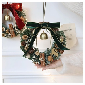 Detail of Christmas wreath featuring velvet bow, pine cones, and gold bells