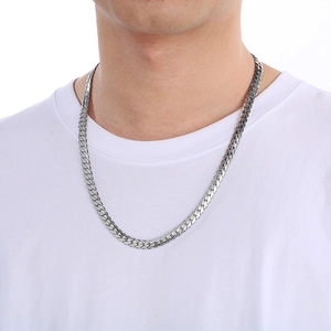 Close-up of a silver flat Cuban link chain necklace on a male model wearing a white T-shirt