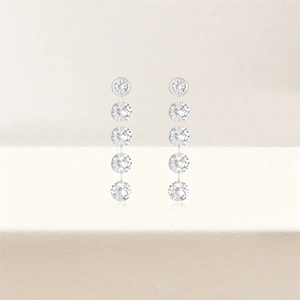 Detail of silver drop earrings featuring five vertically aligned round-cut sparkling diamonds