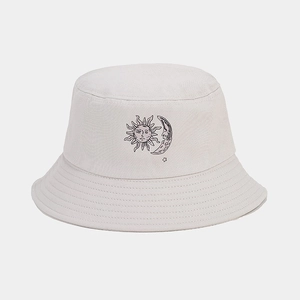 Detailed view of beige bucket hat with sun and moon print and reinforced stitched brim