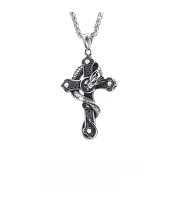 Macro shot of gothic silver cross pendant with dragon and skull detailing