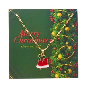 Golden Christmas bell necklace with red enamel and green bow on festive Merry Christmas card