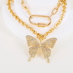 Double-layered golden necklace featuring a crystal butterfly pendant and paperclip chain
