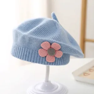 Detail of light blue knit beret for girls with handmade 3D floral decoration