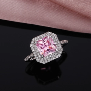 Macro shot of silver ring with square pink zirconia and double halo pavé setting