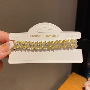 Close-up of double-row bracelet featuring yellow heart-shaped stones in silver prongs
