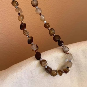 Detail of vintage beaded necklace with multicolored agate stones and metal spacers