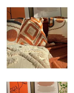 Detail of bohemian tufted pillowcase with geometric orange patterns and soft fringe