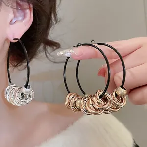 Exaggerated layered hoop earrings with twisted metal rings and beads on black base