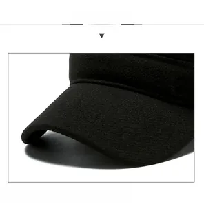 Detail of wool fabric texture and bronze metal logo on black winter flat cap for men