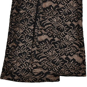 Close-up of black floral lace fabric with nude lining showing intricate texture and details