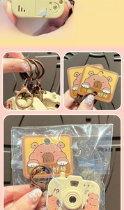 Macro detail of cartoon Capybara camera keychain with a smooth surface and lucky tag