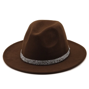 Détail d'un chapeau fedora en laine marron foncé avec un ruban scintillant en argent