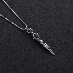 Retro stainless steel vajra scepter pendant on box chain over dark leather texture