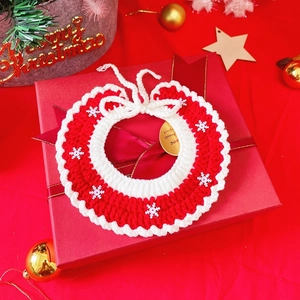 Hand-knitted red and white Christmas pet collar with snowflake on a festive gift box