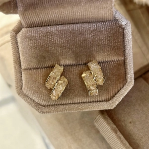 Gros plan de boucles d'oreilles en verre champagne dans un écrin en velours de luxe.