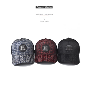 Detailed close-up showing embroidered H patterns and round badges on three baseball caps