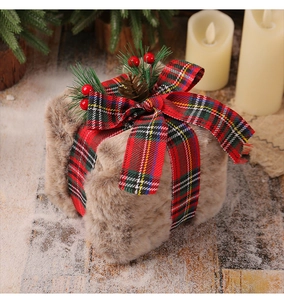 Detail of plush Christmas gift box with pine cones and red berries in a warm festive setting
