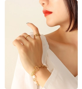 Detail of OT buckle gold chain bracelet with freshwater pearls and square pendant