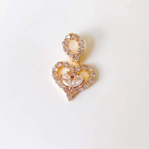 Close-up of golden heart pendant with shimmering crystals and pear-cut diamonds