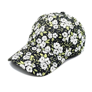 Close-up of floral baseball cap featuring white roses on black fabric with reinforced stitching