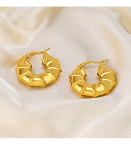 Detail of 18K gold plated bamboo ribbed hoop earrings on elegant silk fabric
