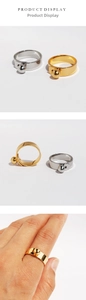 Close-up of belt buckle style ring with metallic ball detail in gold and silver finishes