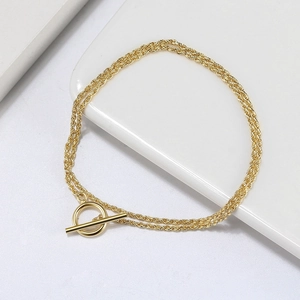 Detailed view of a gold-plated twisted rope chain bracelet featuring a classic T-bar OT clasp