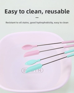 Close-up of silicone spatulas and spoons with telescopic handles over a pink basin