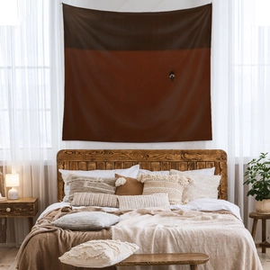 Detail of minimalist dual-tone bohemian tapestry hanging over a wooden bed headboard