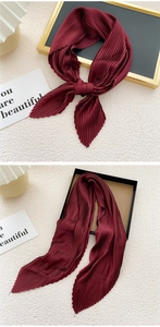 Close-up of pleated burgundy silk scarf showing delicate texture and elegant folding detail