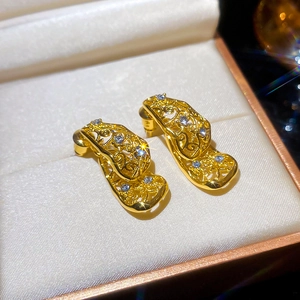 Gros plan détaillé de boucles d'oreilles vintage ajourées avec pampilles en cristal doré