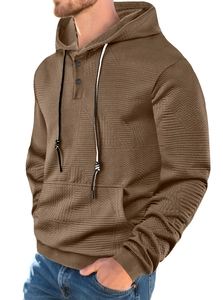 Detail view of brown pullover hoodie featuring geometric textured knit fabric and button placket