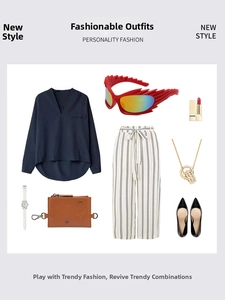 Flat lay of outfit featuring red wing-shaped sunglasses and blue V-neck chiffon top
