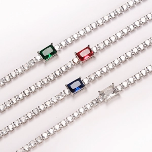 Detailed view of tennis bracelets featuring rectangular emerald, ruby, sapphire, and clear CZ