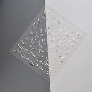 Macro shot of 5D white pearl heart nail stickers with rhinestones on model Co-170