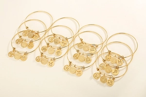 Detailed view of 12 zodiac gold plated wire bracelets with engraved celestial charms