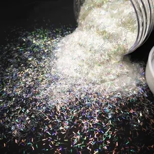 Macro shot of iridescent 3mm cloud glitter sequins pouring from a jar on black surface