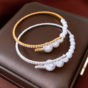 Macro detail of elegant pearl and crystal wrap bracelets in gold and silver finish